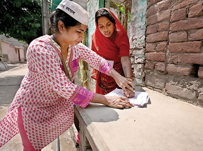An Aam Aadmi Party volunteer helps a Delhi resident put her stamp on the letter to the Delhi CM. The letters, “accepted” by Sheila Dikshit, purportedly state that these residents would not pay what they call are inflated bills.