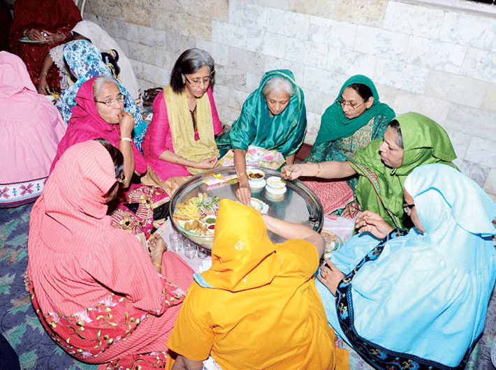 Dawoodi Bohra women eating around a traditional ‘thaal’.