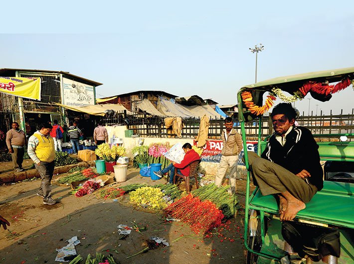 With no customers around,  a vendor and a rickshaw puller bide their time at the  Ghazipur flower mandi 