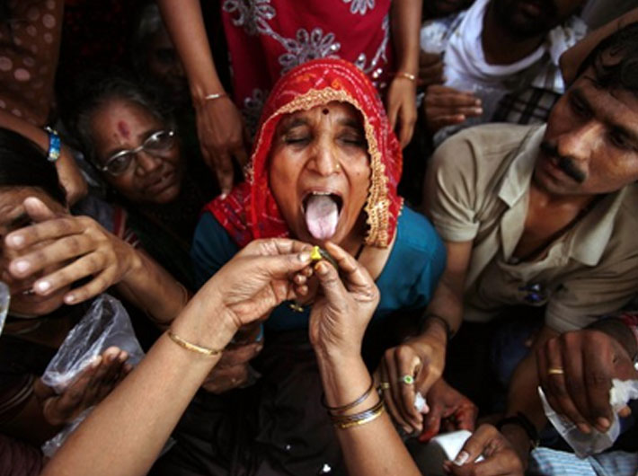 A faithful takes a dose of fish `medicine` – called prasadam – to cure asthma as the two-day annual event got under way in Hyderabad on June 8.
