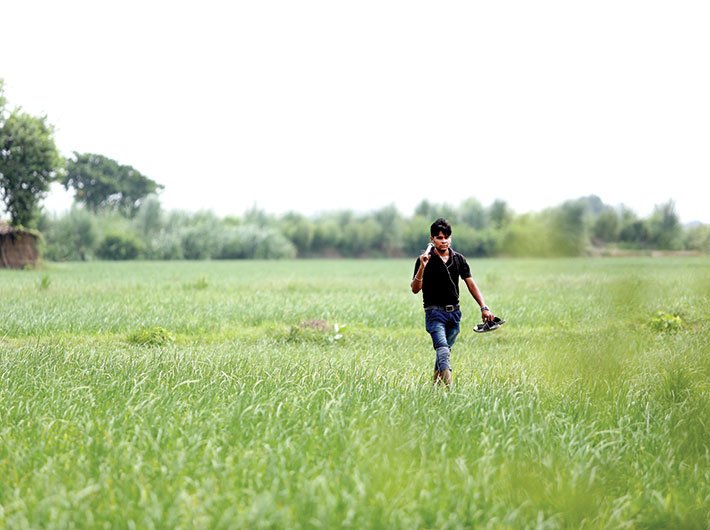 Amit (left), who has crorepati dreams, in his fields. (Photo: Arun Kumar)