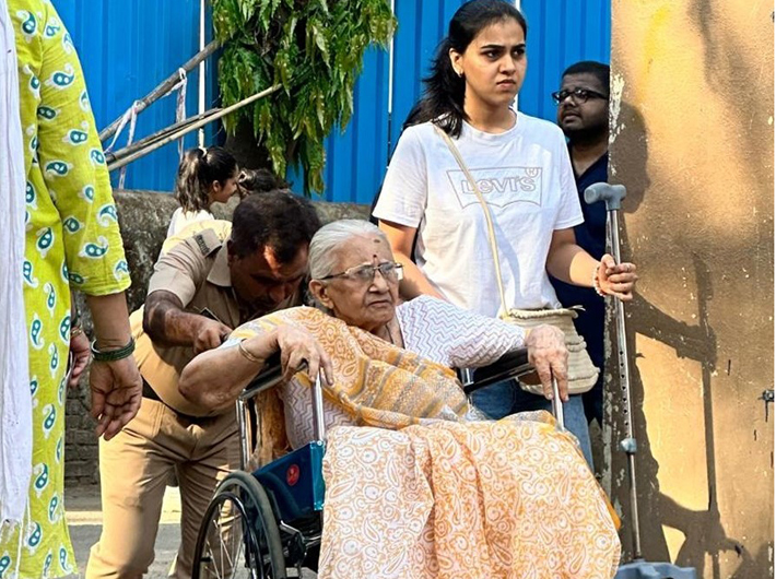 An elderly voter being helped to reach the polling booth in Mumbai on Monday