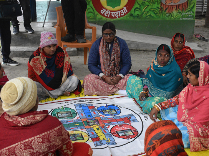 A group of women playing a ludo game on the importance of participation in local institutions like gram sabhas (Image courtesy: S M Sehgal Foundation)