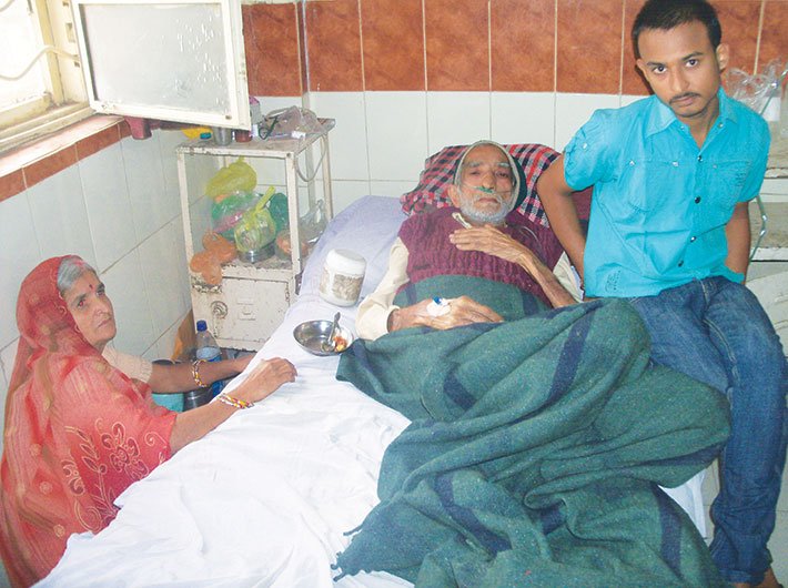 Pradeep Gehlot and his mother with his ailing father Srikrishna. Photo courtesy: Swasthya Adhikar Manch