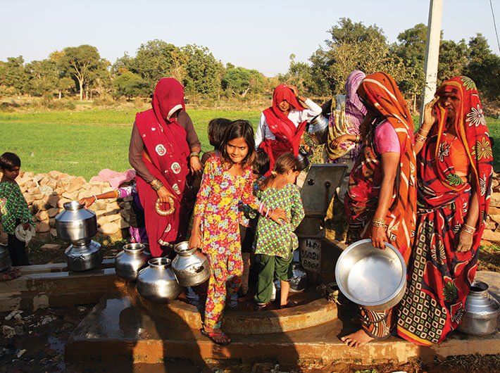 Women and children wait for their turn to fill water from a hand-pump in Bundelkhand