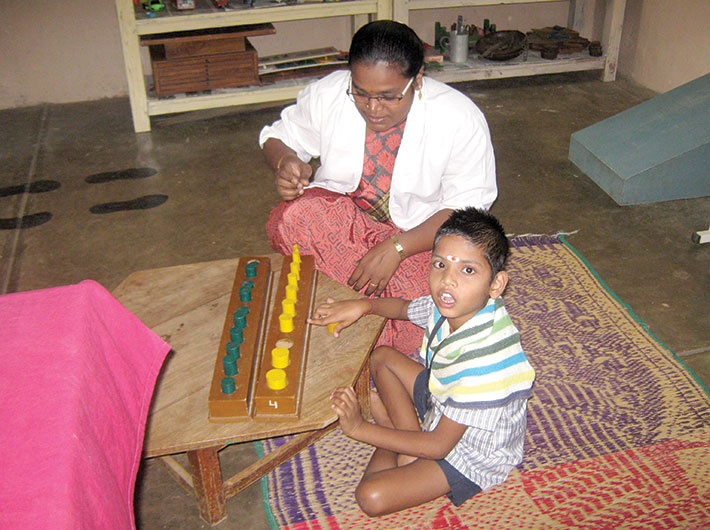 Kabila Devi, a qualified physiotherapist, gives therapy to a child 